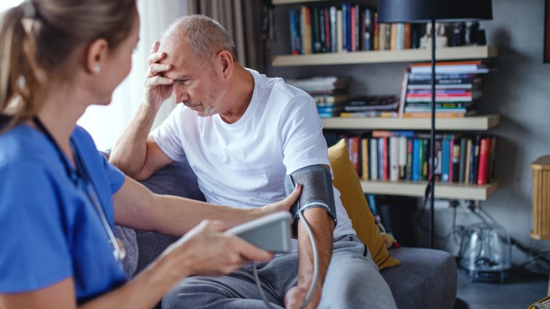 Eine Krankenschwester misst den Blutdruck bei einem Mann