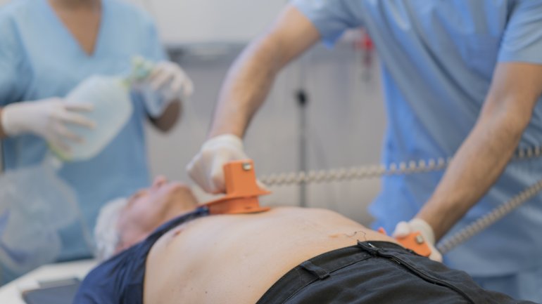 Mann wird mit Defibrillator behandelt